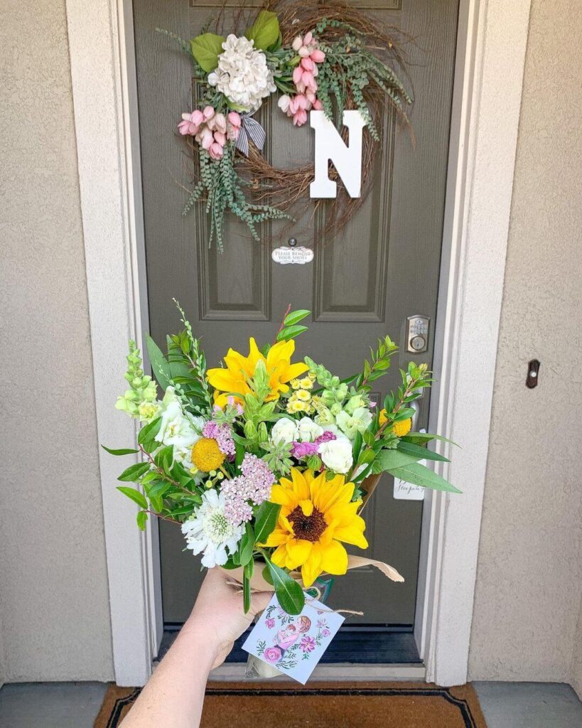A bouquet is held in front of a front door