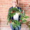Woman hold wreaths made at workshop hosted by Bloom Sacramento