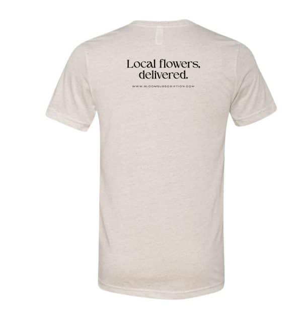Oatmeal colored shirt with text "local flowers, delivered" on the back.