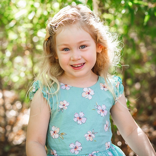 Young girl poses for school photo outdoors