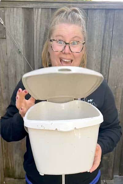 Amanda from Bloom Sacramento holds an open countertop compost pail
