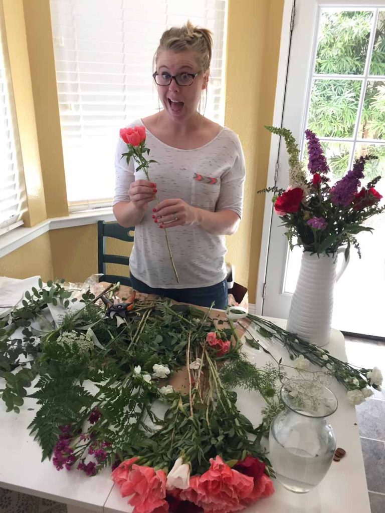 Amanda arranging flowers in her kitchen.