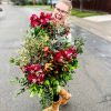 Amanda Kitaura of Bloom holding red flowers grown locally