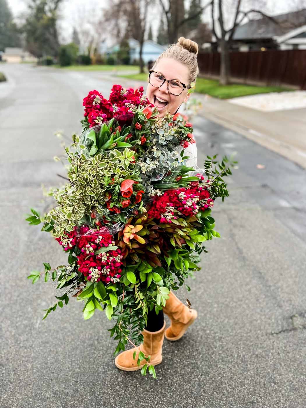 Amanda Kitaura of Bloom holding red flowers grown locally