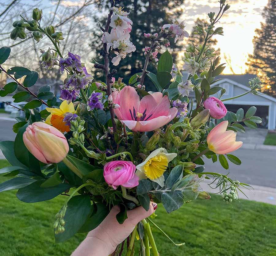 Hand holds up bouquet made by Bloom in Sacramento
