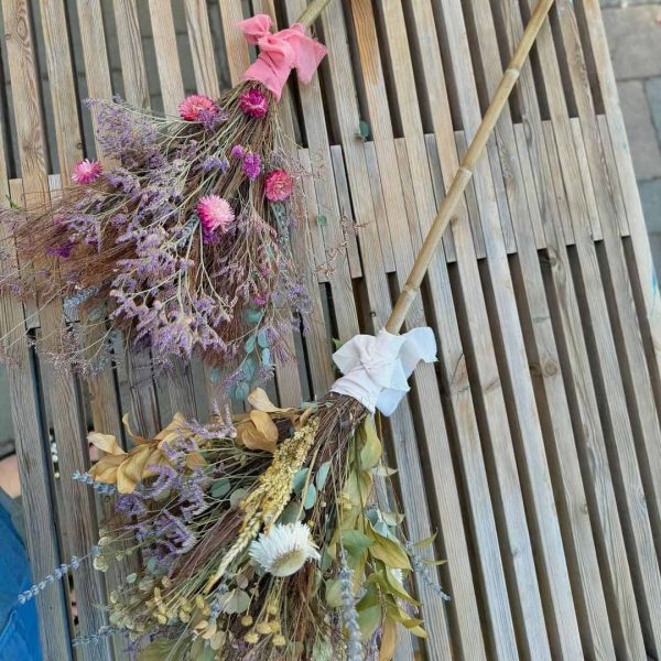 Two dried flower brooms made by Bloom Sacramento sit on a table