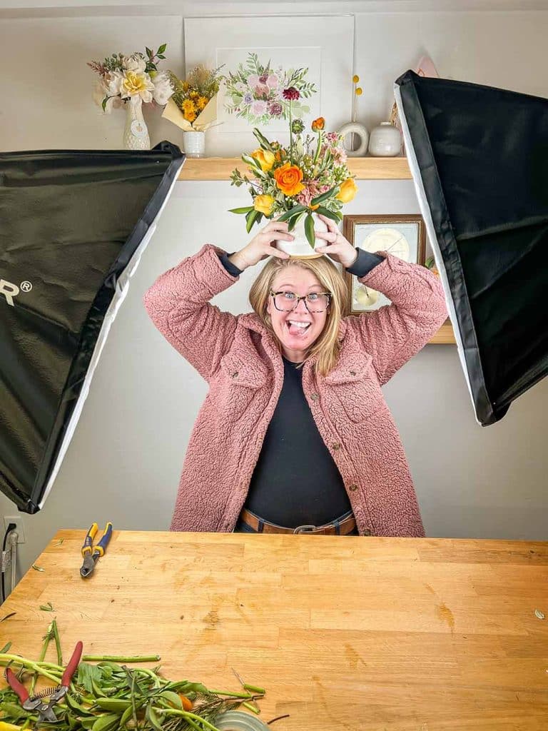 Amanda of Bloom Sacramento balances a floral arrangement on her head while filming a live video for the Flower Club.