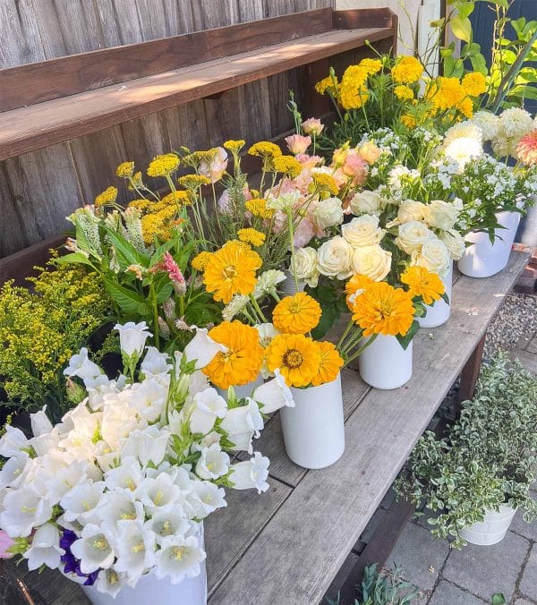 Buckets of flowers sitting on a bench at a Bloom workshop in Sacramento