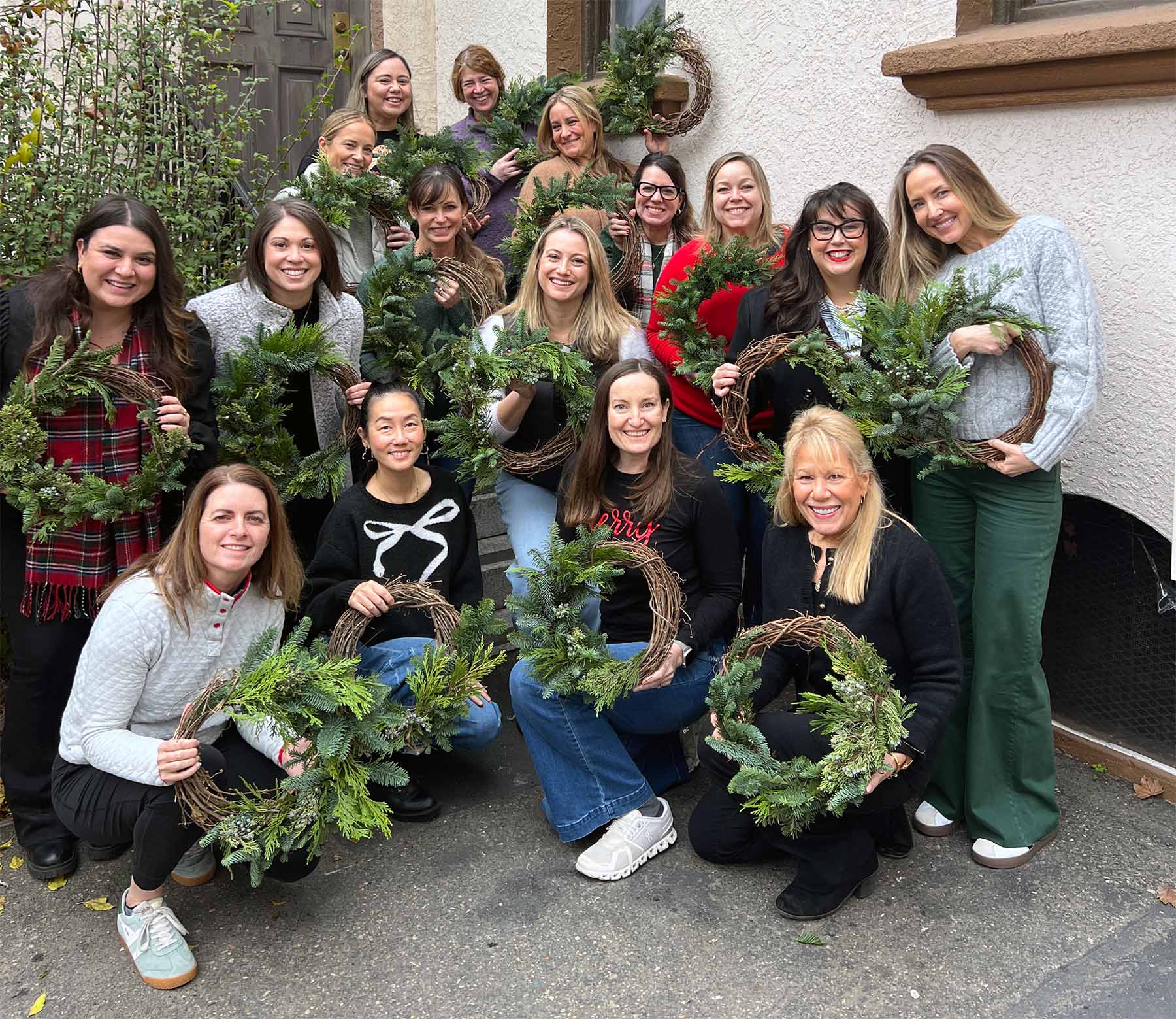 Group of people holding wreaths they made at a Bloom Sacramento workshop